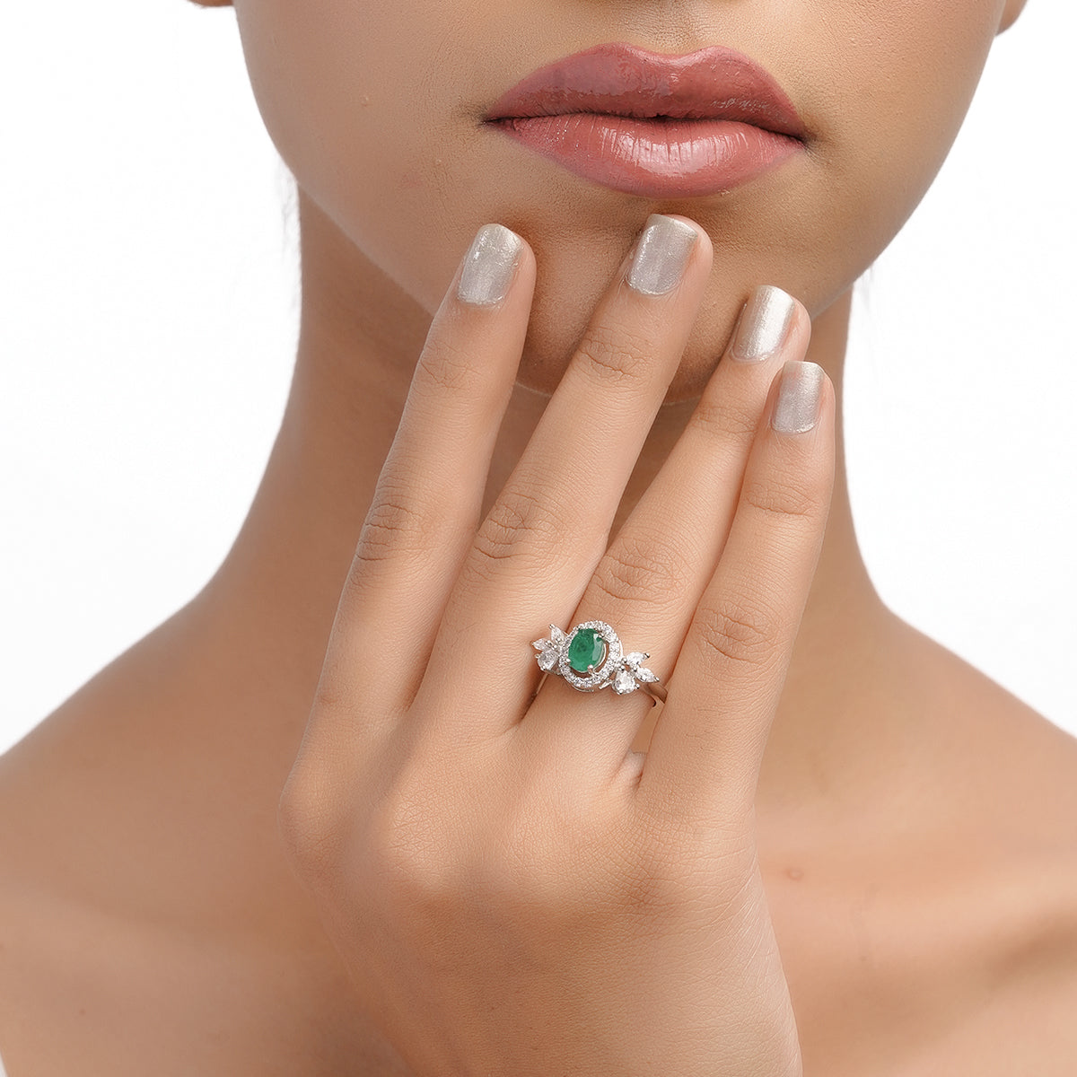 Model hand close-up showing green CZ ring with white stones
