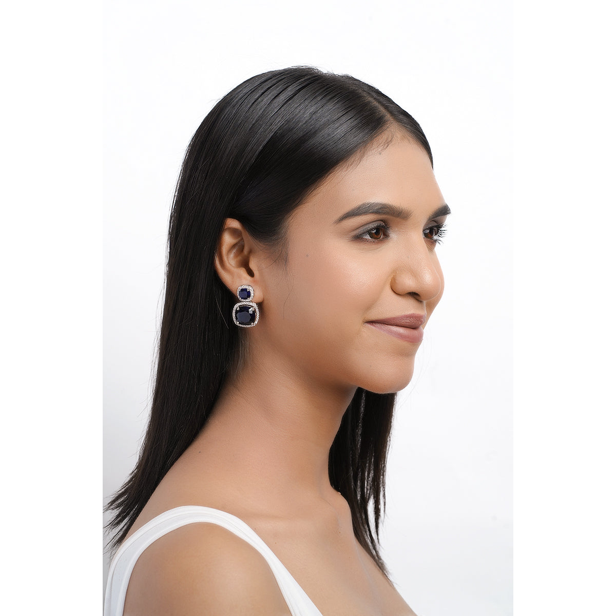 Full face of model wearing bold blue CZ drop earrings
