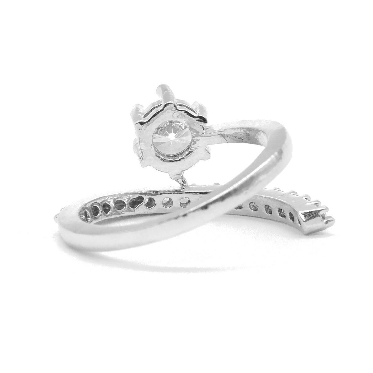 A silver-toned ring with a decorative floral crown-like top and a curved band featuring small inset stones, shown on a plain white background.