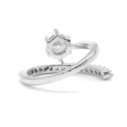 A silver-toned ring with a decorative floral crown-like top and a curved band featuring small inset stones, shown on a plain white background.