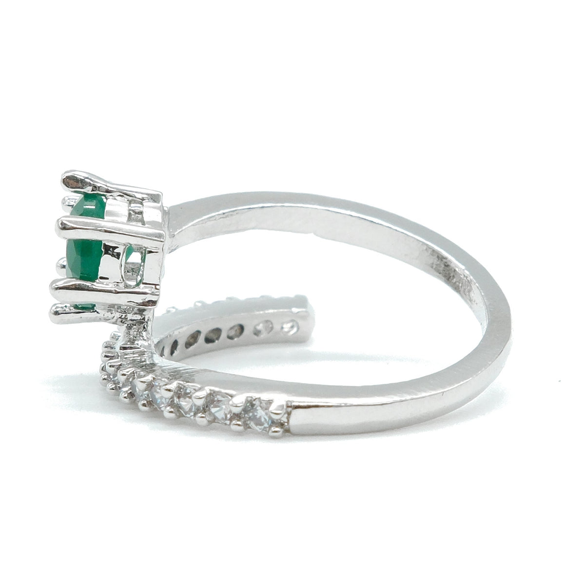 A silver ring featuring a cluster of green gemstones at the top and a curved row of small clear stones along the band, shown on a plain white background.