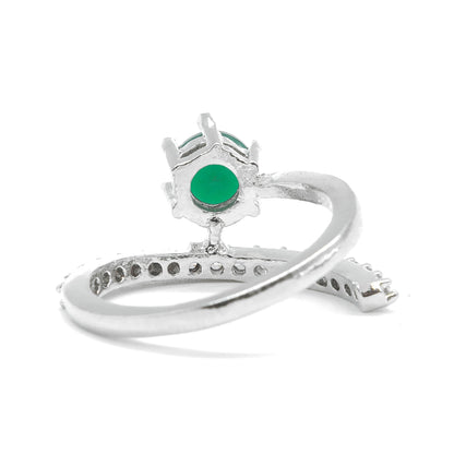 A silver ring featuring a round green emerald-cut gemstone in a crown-like setting, with a curved band accented by small pavé-set stones, shown on a white background.