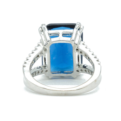 A silver-toned ring featuring a large rectangular blue gemstone in a prong setting, shown against a plain white background.