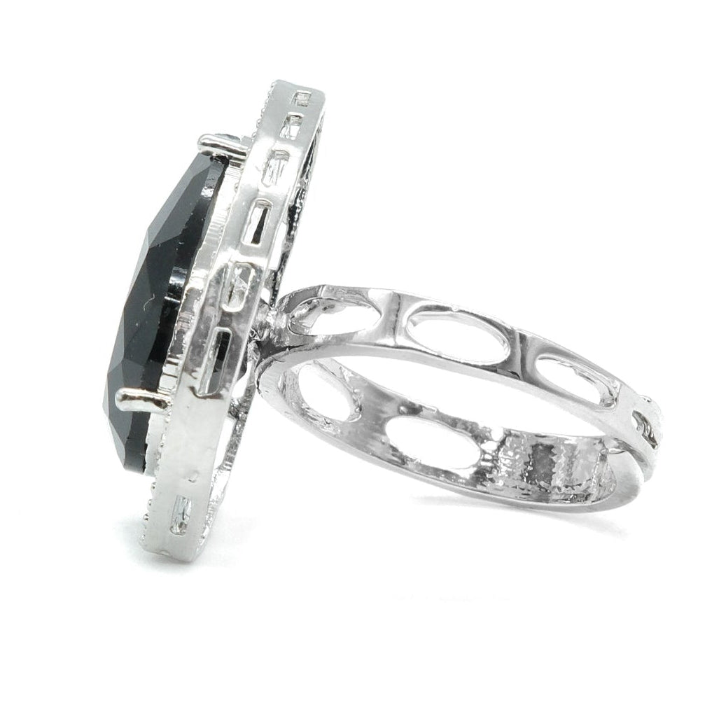 A silver ring featuring a large oval black gemstone in a textured bezel setting, with an openwork patterned band, shown on a white background.