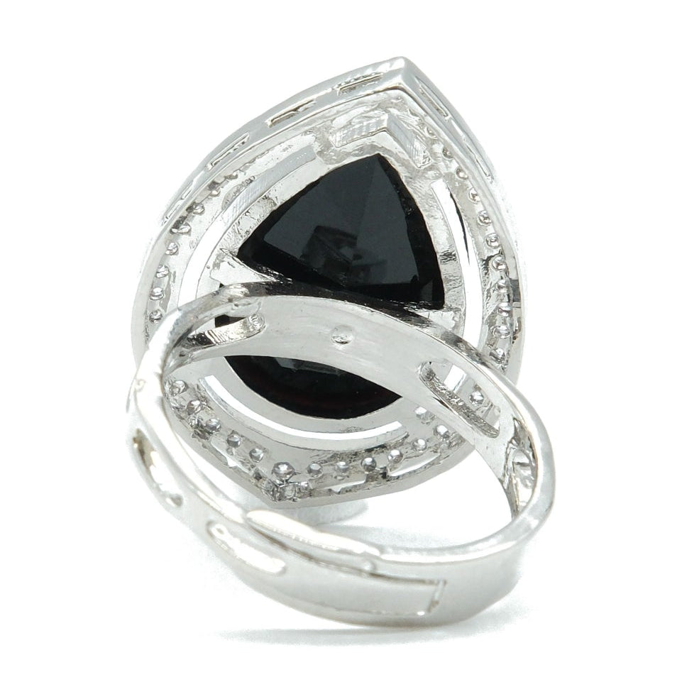 A silver-toned ring featuring a large triangular black gemstone in a marquise-cut setting, surrounded by smaller clear stones, on a plain white background.