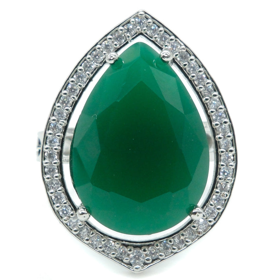 A teardrop-shaped green gemstone ring with a silver-toned halo setting accented by small clear stones, shown on a plain white background.