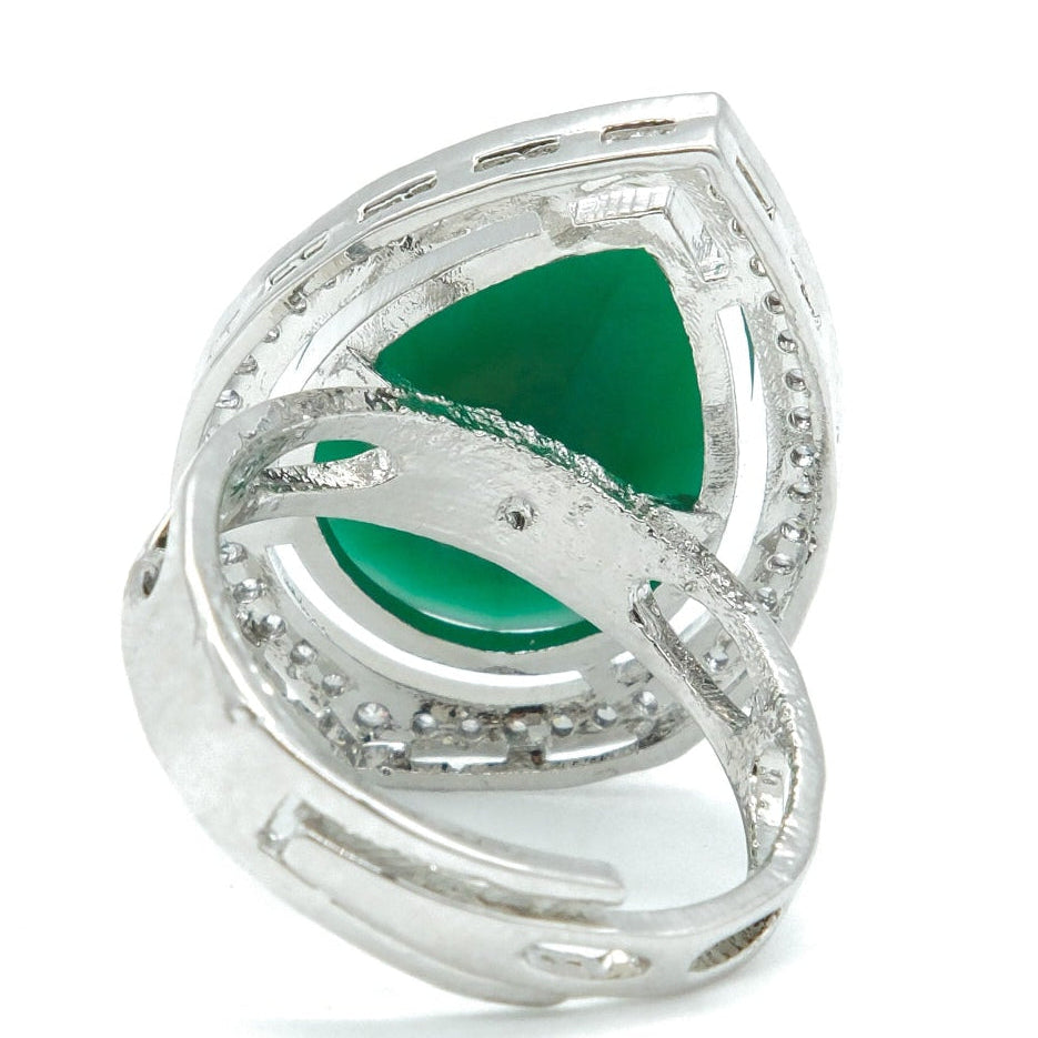 A silver ring featuring a triangular green gemstone surrounded by small clear stones, set against a plain white background.