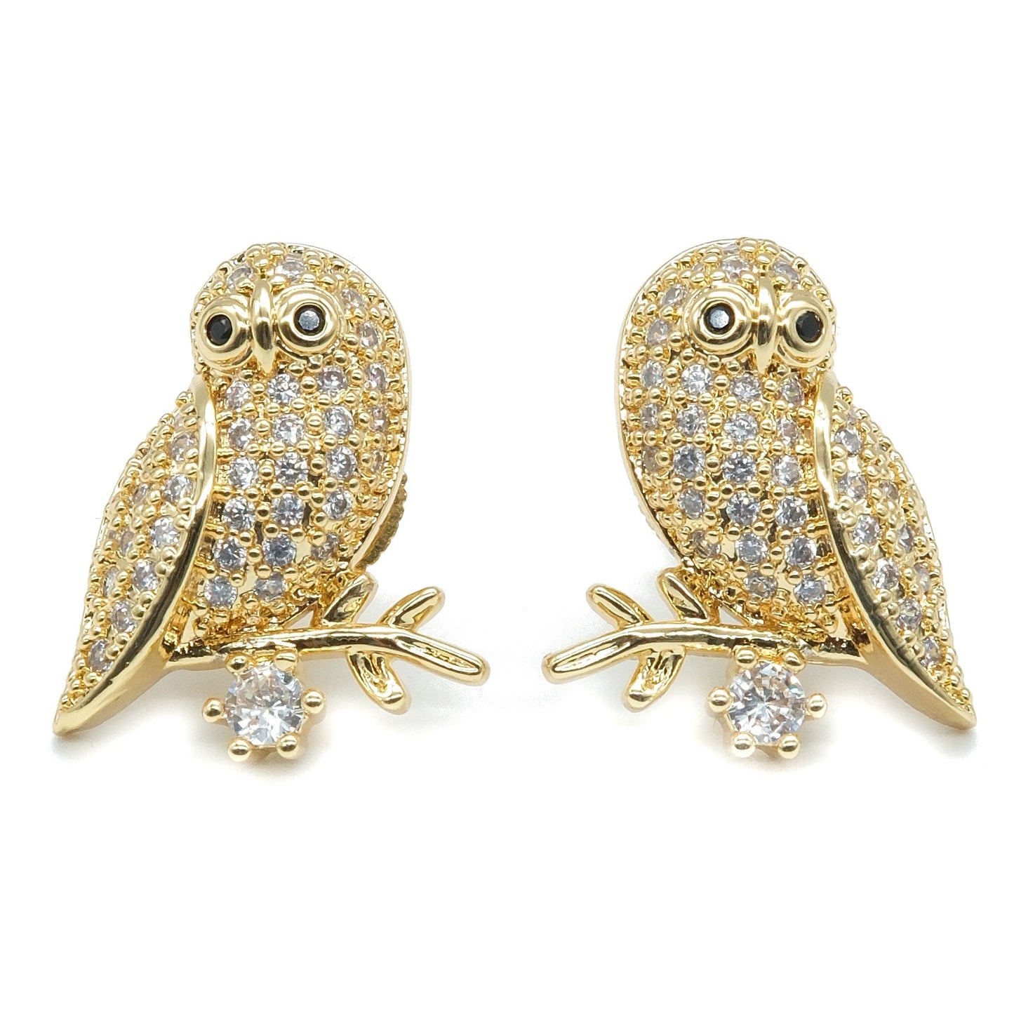 A pair of gold owl stud earrings paved with clear crystals, perched on small branches with a single clear crystal below each, shown on a plain white background.
