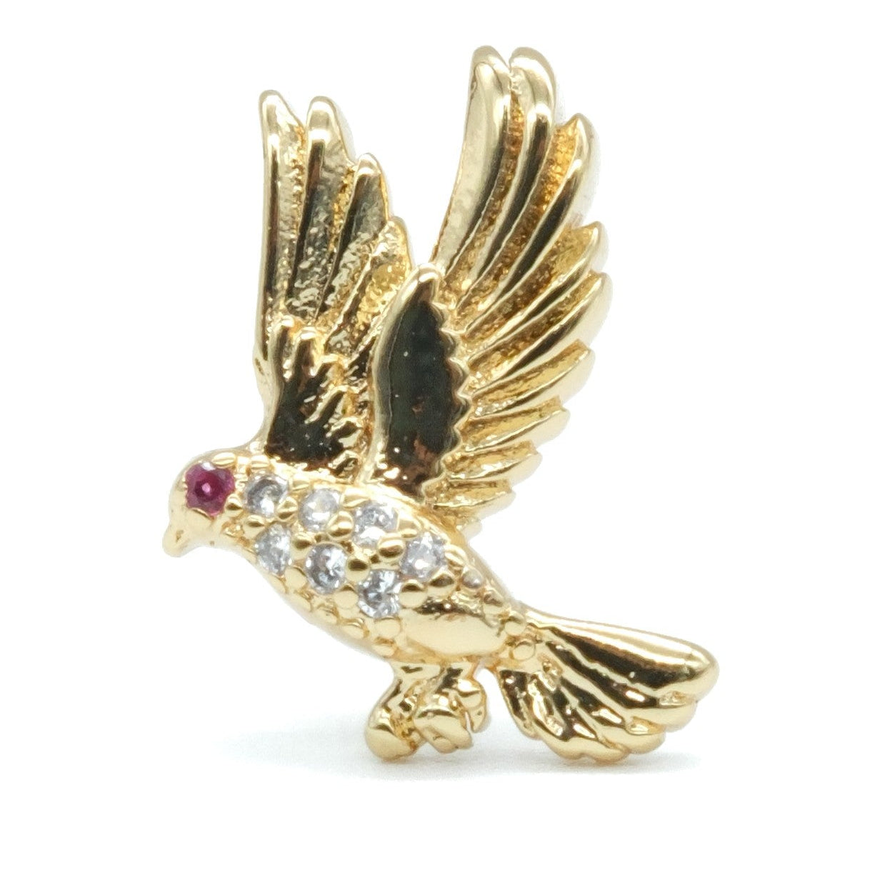 A gold bird brooch with wings spread, featuring a small red gemstone for the eye and clear rhinestones on its chest, set against a plain white background.