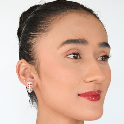 Woman wearing silver hoop earrings on a white background