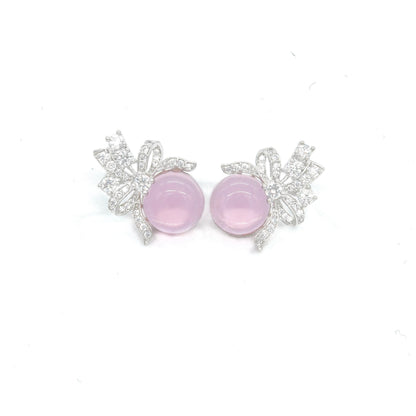Front view of green stud earrings with bow design and white stones