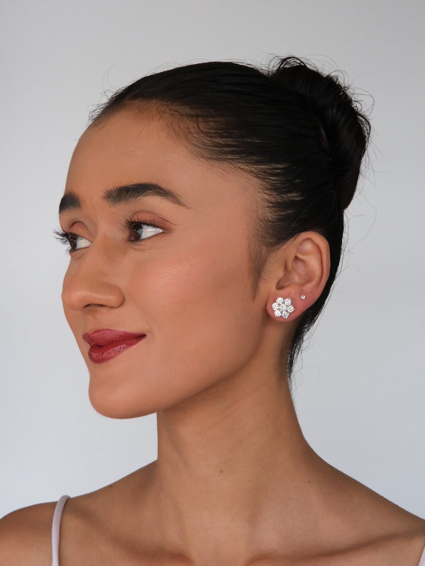 Model in a side pose wearing Floral American Diamond Stud Earrings, showcasing the elegant floral design and sparkling American diamonds.