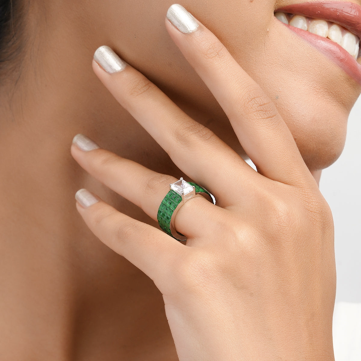 Smiling model showing green wide band ring on hand