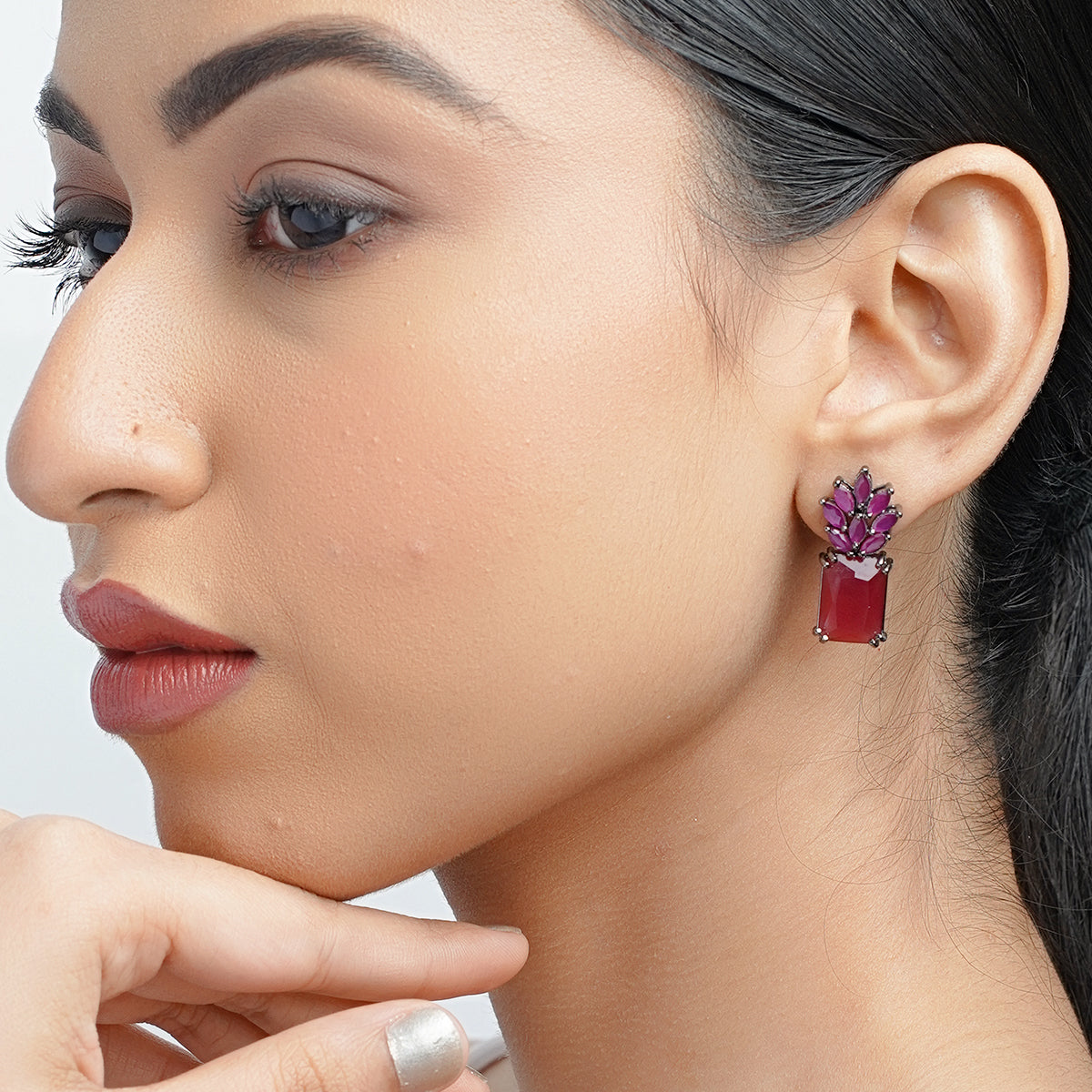 Model close-up wearing ruby pink sapphire dangle earring