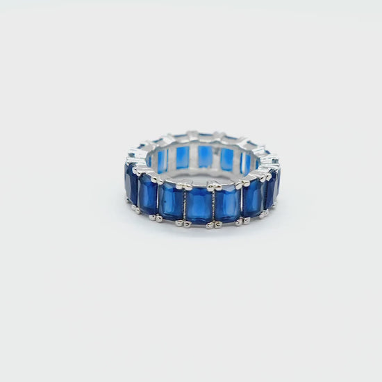 Close-up product video of the Blue Baguette Eternity Ring on a white background, showcasing the sparkling blue baguette stones and elegant eternity band design.