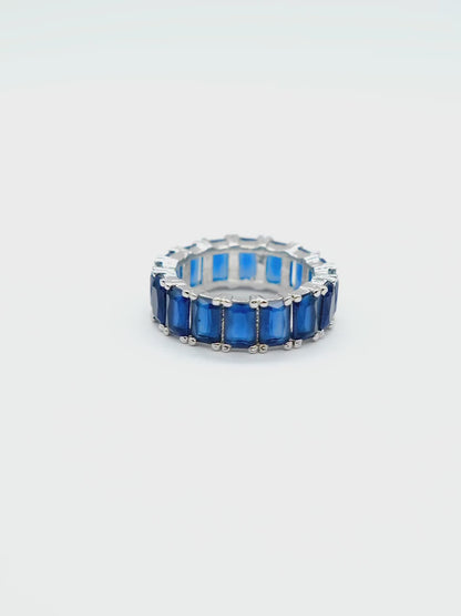 Close-up product video of the Blue Baguette Eternity Ring on a white background, showcasing the sparkling blue baguette stones and elegant eternity band design.