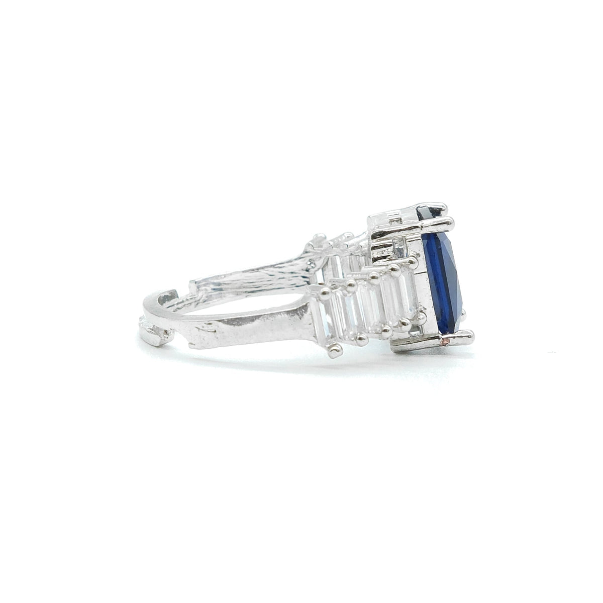 side view of blue stone ring with white background