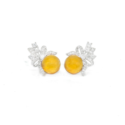 Front view of yellow stud earrings with bow design and white stones
